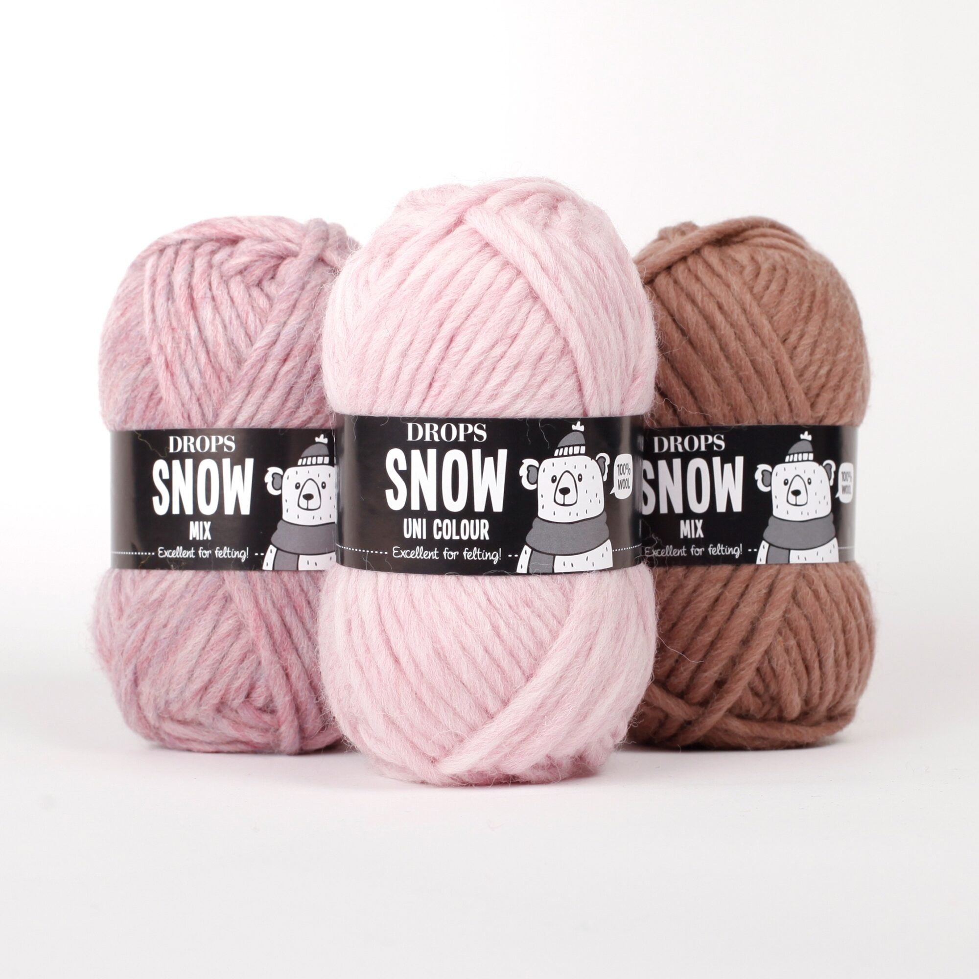 Filato DROPS Snow rosa, rosa peonia e marrone Tre gomitoli di filato DROPS Snow nei colori rosa, rosa peonia e marrone con etichette visibili.